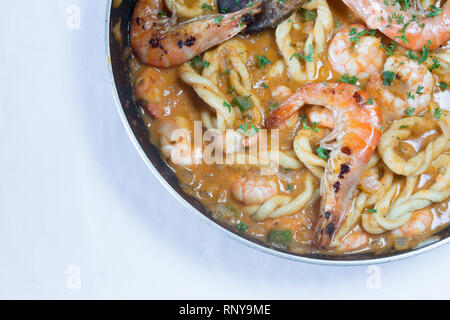 Handgearbeitete sardische Spezialitäten Pasta, Lorighittas, mit Garnelen und Meeresfrüchte Sauce in die Pfanne bereit zu dienen. Stockfoto