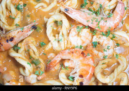 Handgearbeitete sardische Spezialitäten Pasta, Lorighittas, mit Garnelen und Meeresfrüchte Sauce in die Pfanne bereit zu dienen. Stockfoto