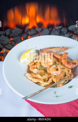 Eine pasta Schüssel mit sardischen Spezialitäten Lorighittas Nudeln mit Meeresfrüchten und Tomatensauce mit frischer Zitrone Keil garniert serviert. Stockfoto