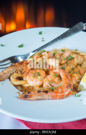 Eine pasta Schüssel mit sardischen Spezialitäten Lorighittas Nudeln mit Meeresfrüchten und Tomatensauce mit frischer Zitrone Keil garniert serviert. Stockfoto