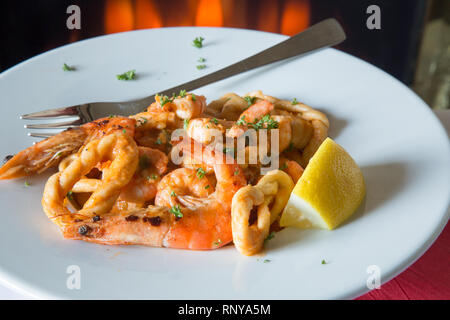 Eine pasta Schüssel mit sardischen Spezialitäten Lorighittas Nudeln mit Meeresfrüchten und Tomatensauce mit frischer Zitrone Keil garniert serviert. Stockfoto