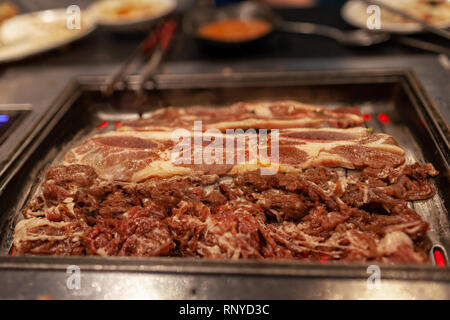 Koreanisches Barbecue mit Saftigem rohem Rindfleisch und Rippchen am heißen Herd platte Grill. Stockfoto