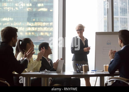 Diverse Geschäftsleute dankbar applaudieren zu Lautsprecher mit Präsentation gratulieren. Stockfoto
