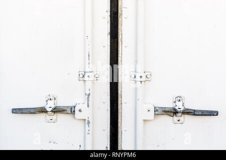 Nahaufnahme der gesperrten Türgriffe eines weißen Shipping Container. Stockfoto
