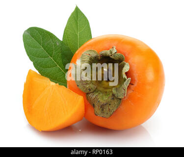 Scheibe und ganze Persimmon mit grünen Blättern auf weißem Hintergrund Stockfoto