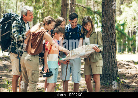 Familie Lesen einer Karte im Wald Stockfoto