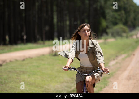 Junge Frau im Wald Radfahren Stockfoto