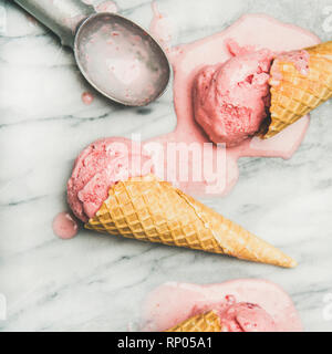 Gesunde kalorienarme Sommer Nachtisch. Selbstgemachte Erdbeer Joghurt Eis in süßen Waffeln auf über grauem Marmor tisch Hintergrund, Ansicht von oben, in der Nähe - u Stockfoto