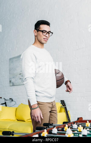Jungen gemischten Rennen Mann in Weiß sweatshirt stehen Tischfußball Stockfoto