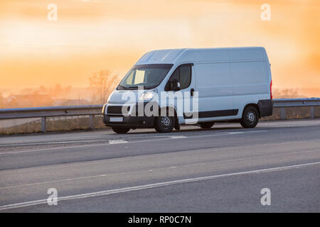 Minibus geht auf das Land Highway entlang der Wald Stockfoto