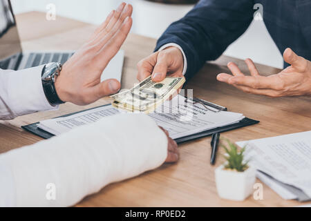 7/8-Ansicht von die Ablehnung Geld geben Geschaeftsmann in der blauen Jacke am Tisch im Büro, Entschädigung Konzept Stockfoto