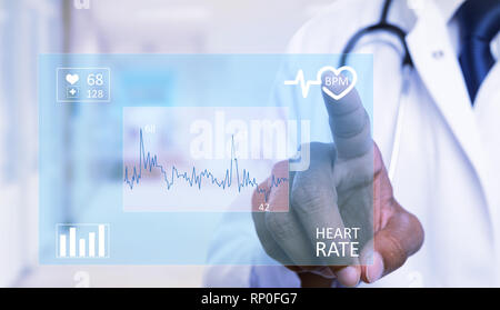 Close-up indischen männlichen Kardiologie medic berühren Herz Symbol auf unsichtbar Anzeige mit Zeigefinger als futuristisch Medizin Konzept Stockfoto