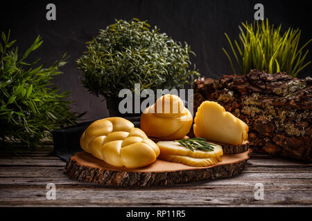Auswahl von geräucherten geflochtene Käse auf rustikalen Holzmöbeln Hintergrund Stockfoto