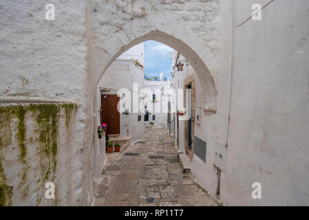 Ein Blick auf die Straße der alten Stadt - Provinz Brindisi, Apulien. Malerische schmale mit traditionellen weiß getünchten Häusern. Ostuni, Apulien, Italien Stockfoto