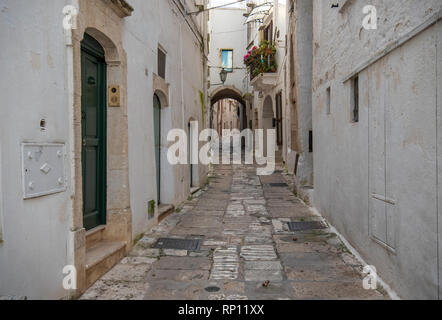 Ein Blick auf die Straße der alten Stadt - Provinz Brindisi, Apulien. Malerische schmale mit traditionellen weiß getünchten Häusern. Ostuni, Apulien, Italien Stockfoto