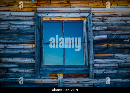 Eine Nahaufnahme eines Fensters einer Holzhütte in Russland. Stockfoto