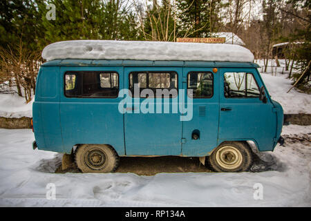 Ein UAZ-452 oder ´Brotlaib´ aus der sowjetischen Ära Fahrzeugbau sitzt im Schnee in einem kleinen russischen Dorf Stockfoto