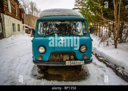 Ein UAZ-452 oder ´Brotlaib´ aus der sowjetischen Ära Fahrzeugbau sitzt im Schnee in einem kleinen russischen Dorf Stockfoto