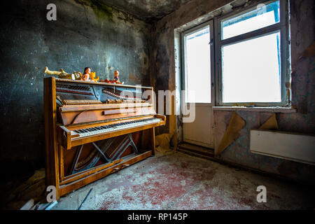 Ein Klavier sitzt seit der Katastrophe ungespielt in einem Raum einer verlassenen Wohnung in Pripyat, Tscherwjschow, Ukraine. Stockfoto