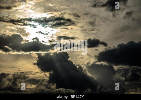 Die Sonne strahlt durch den bewölkten Himmel/. Stockfoto