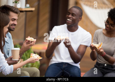 Fröhliche diverse Studenten machen eine Pause essen Pizza trinken Kaffee Stockfoto