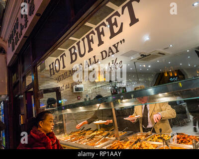 Chinesische warmes Buffet Auswahl' Essen, so viel Sie möchten 'Fenster, mit orientalischen Frau anerkennend auf die chinesische Küche Sorten auf "Offen" anzeigen. Wardour Street Chinatown Soho London UK Stockfoto