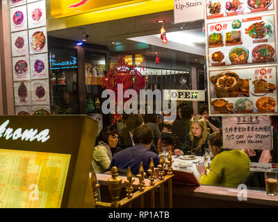 Das chinesische Restaurant Fenster Chinatown Soho London beschäftigt, junges Publikum beliebten chinesischen Restaurant in der Dämmerung mit bebilderter Probe Menüs Aroma Restaurant Gerrard Street London W1 Stockfoto