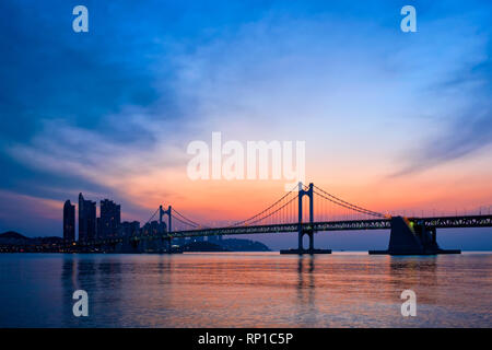 Gwangan Brücke auf sunrise mit Wolkenkratzern und dramatischen Himmel. Busan, Südkorea Stockfoto