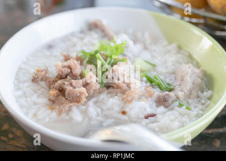 Nahaufnahme einer gekochten Reis mit Schweinefleisch in einer Schüssel auf den Tisch für das Frühstück. Wählen Sie Fokus flache Tiefenschärfe. Stockfoto