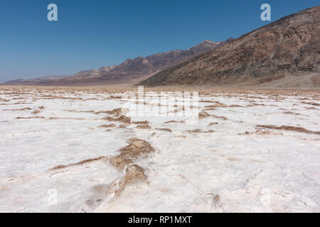 Autos entlang Badwater Road fahren (direkt vor dem Fuß des Mt Perry, Badwater Basin, Death Valley National Park, California, United States sichtbar Stockfoto