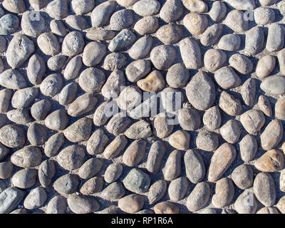 Echten Kieselsteinen Straße in dem sonnigen Tag Hintergrund Textur Stockfoto