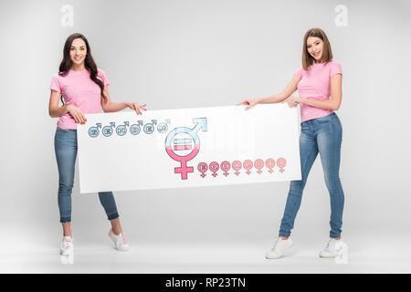 Schöne Frauen mit großen Schild mit der Gleichstellung der Geschlechter Symbol auf grauem Hintergrund Stockfoto