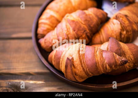 Frisch gebackene Croissants auf hölzernen Tisch, frische Croissants, Frühstück Brötchen Stockfoto