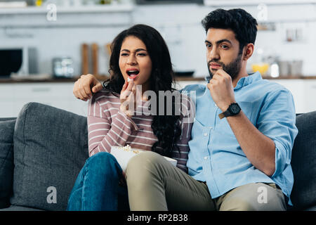 Hispanic paar Fernsehen beim Essen Popcorn zu Hause Stockfoto