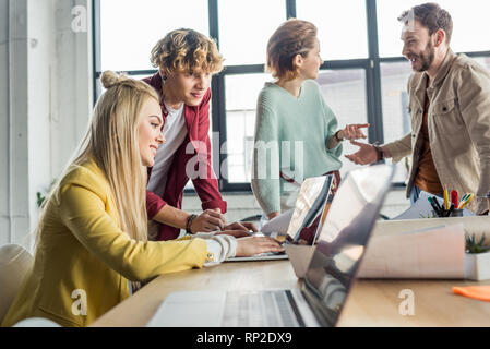 Gruppe von weiblichen und männlichen Architekten Arbeiten am Laptop und in der Diskussion im Loft Büro Stockfoto