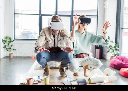 Weibliche und männliche Architekten gestikulierte mit Händen, während in der virtuellen Realität im Loft Büro aufgeregt Stockfoto