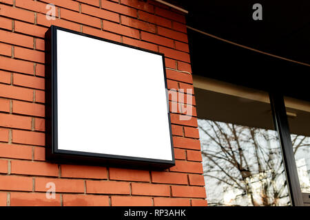Leeres quadrat Namensschild, business Licht Anmelden mock up auf der Mauer eines kleinen Business Workshop store montiert Stockfoto