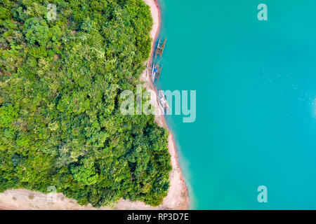 (Sicht von oben) einen atemberaubenden Blick auf einen der grünen Küste von einer tropischen Insel mit einigen traditionellen Fischerboote in Nam Ngum Stausee. Stockfoto