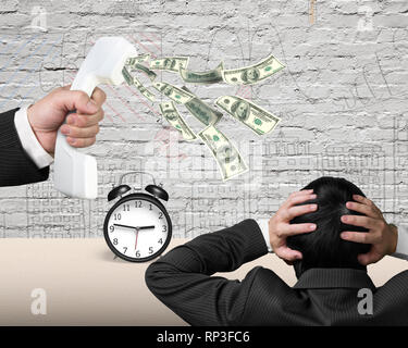 Hand mit weißen Telefonhörer mit Geld aus Spritzen mit einem anderen Mann, Wecker und Mauer Hintergrund. Stockfoto