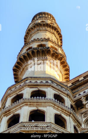 Eine Nahaufnahme eines der minarette von Charminar, vier Minaretten, in Hyderabad, Indien. Vollmond ist sichtbar in der oberen rechten Ecke des Rahmens. Stockfoto