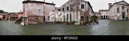 Ostia Antica Rom, Italien, 24. Januar 2019: Überblick über das mittelalterliche Dorf von Ostia Antica und Saint' Aurea Kathedrale in einem trüben Wintertag Stockfoto