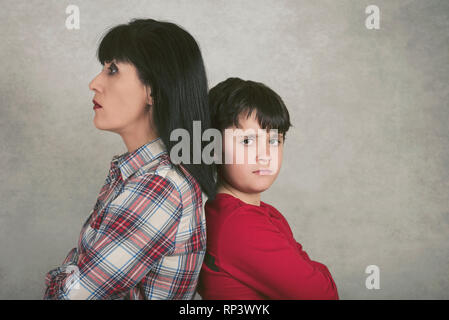Mutter und Sohn, der gegen den grauen Hintergrund sind wütend Stockfoto