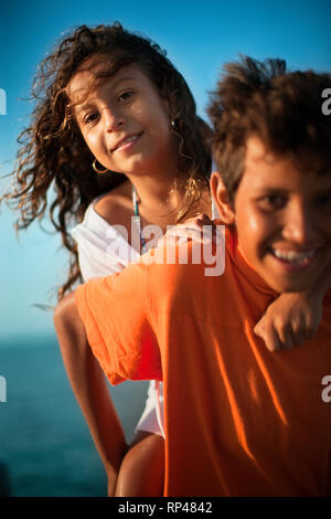 Junge, die Schwester auf seinem Rücken Stockfoto