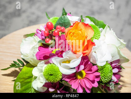 Herrlich bunten Blumenstrauß mit Rosen und Lisianthus Blumen auf dem Holztisch. Blumenschmuck hautnah. Schönheit, frisch. Stockfoto