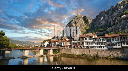 Amasya osmanische Villen an den Ufern des Flusses Yeşilırmak, unterhalb der pontischen Königlichen Felsengräber und Mountain Top alte Zitadelle bei Sonnenuntergang, Türkei Stockfoto