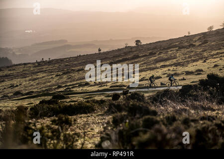 Zwei Männer mit dem Rennrad Fahrrad auf einem Hügel in der Nähe Haytor in Dartmoor in Devon, England in der Morgendämmerung. Stockfoto