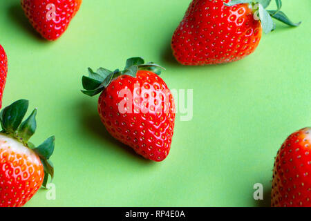 Haufen von frischen Erdbeeren auf grünem Hintergrund Nahaufnahme Stockfoto