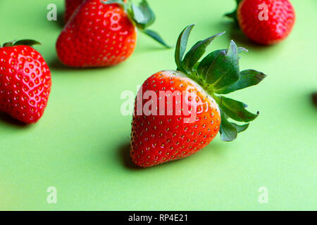 Haufen von frischen Erdbeeren auf grünem Hintergrund Nahaufnahme Stockfoto