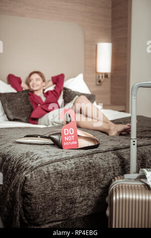 Blonde Geschäftsfrau in Ruhe im Hotel Zimmer nach Flughafen Stockfoto