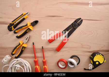 Elektrische Reparaturen Werkzeuge auf Holztisch. Horizontale Komposition. Ansicht von oben. Stockfoto